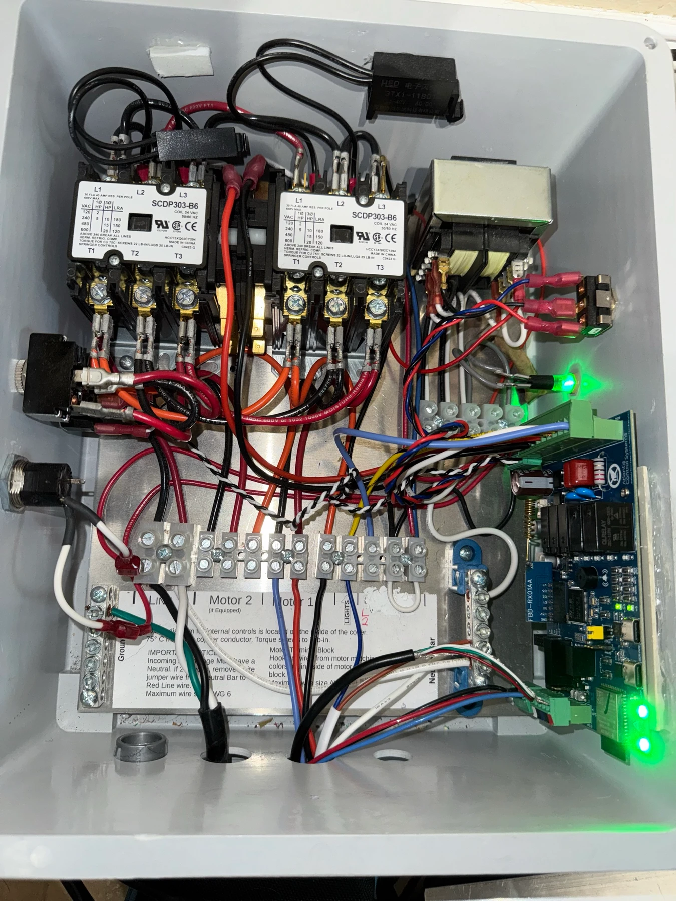 X4.4 controller installed in an existing lift control box, shown with the cover removed